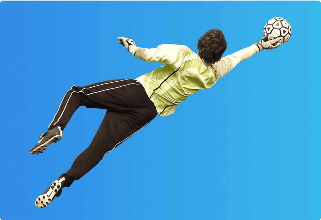 Soccer goalkeeper diving mid-air to make a save with one hand.