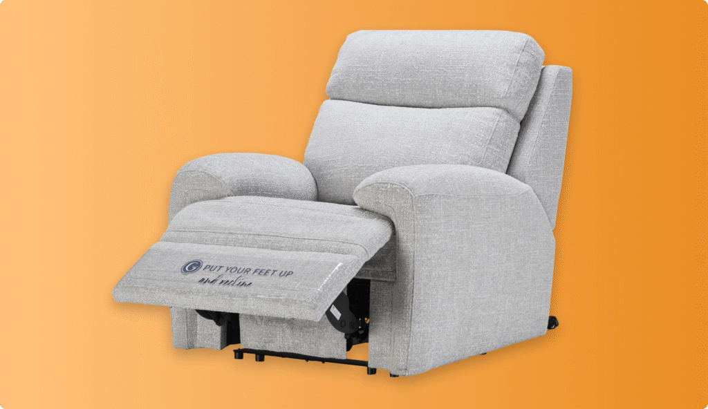 Grey fabric recliner chair with cushioned armrests and extended footrest on an orange background.