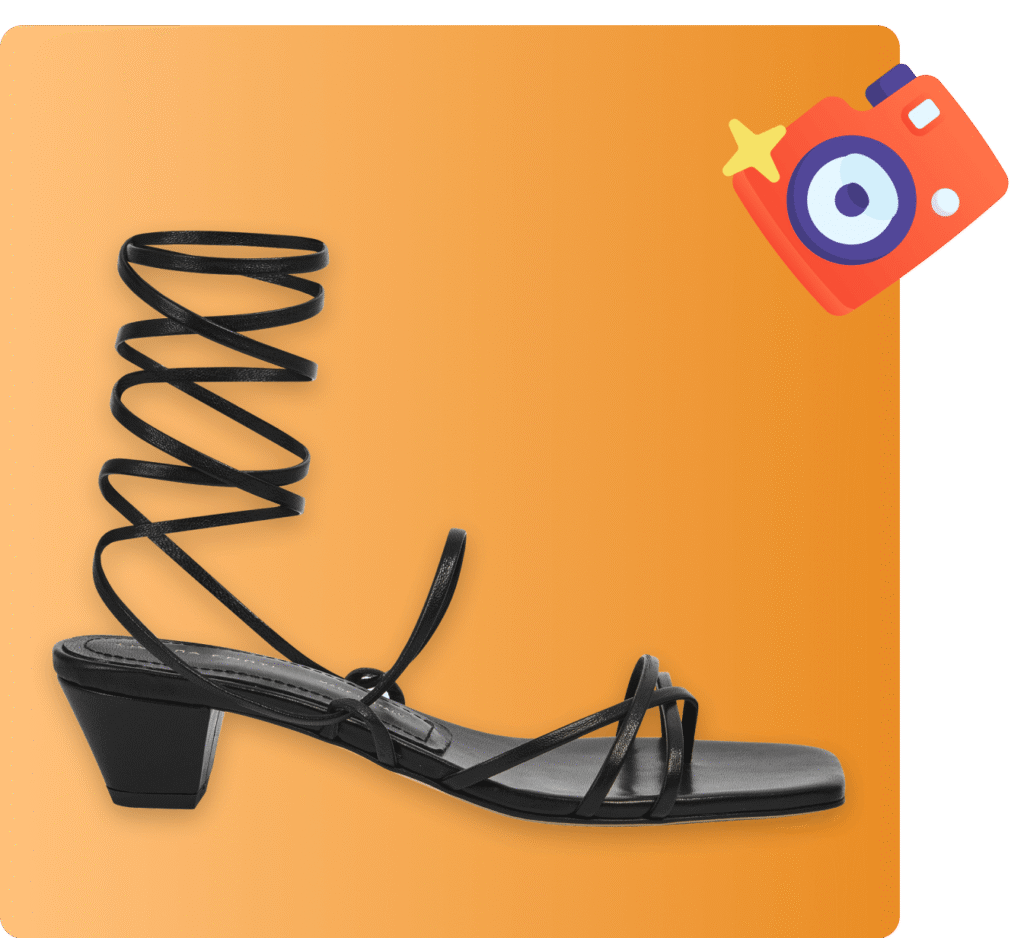 Black strappy sandal with low block heel and spiral ankle wrap on an orange background.