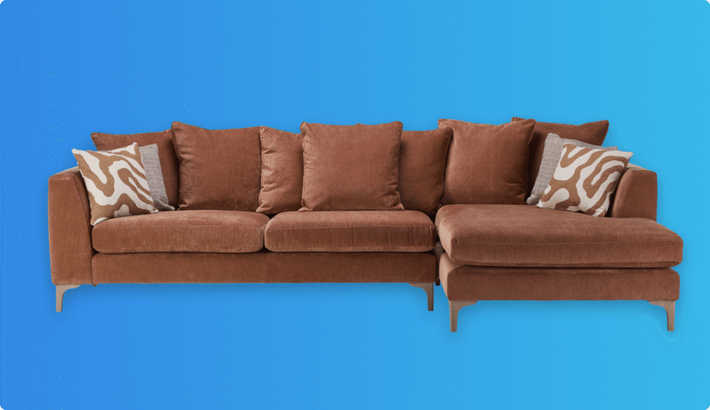 Brown upholstered sofa with zebra-patterned cushions on a blue background.