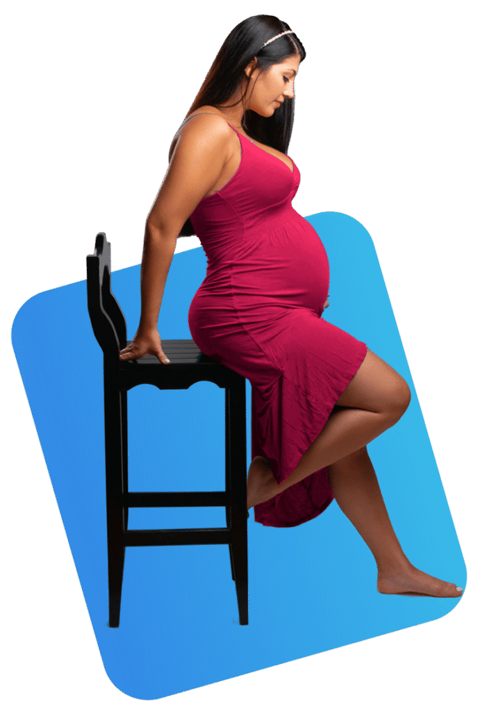 Pregnant woman in a red dress sitting on a chair against split white and orange background