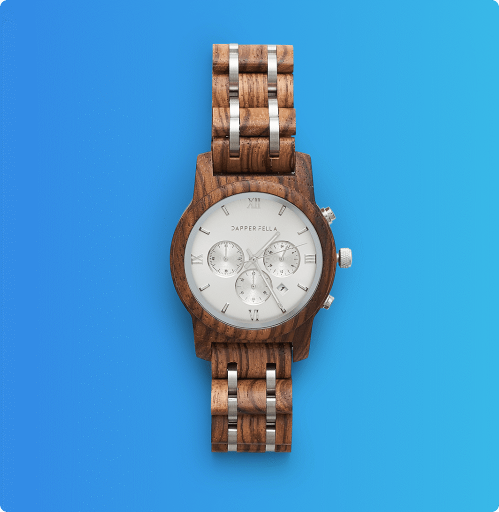 Luxury wristwatch with dark dial, silver casing, and brown leather strap on a light gray background.