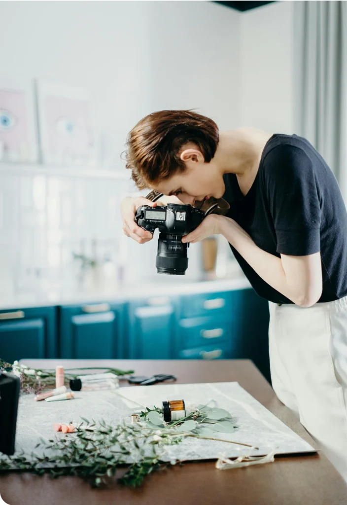 Photographer capturing flat lay product shot with camera in a styled studio setting.